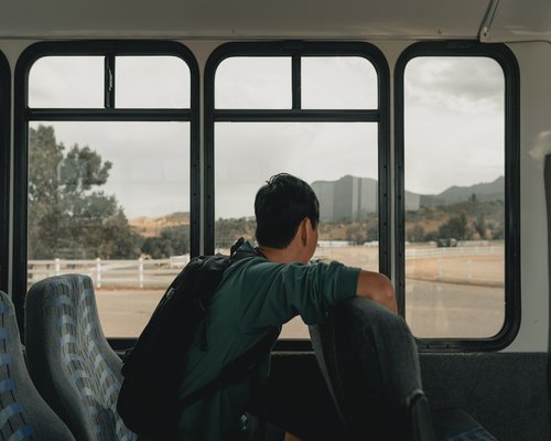 Person commuting on a bus reading a book comfortably